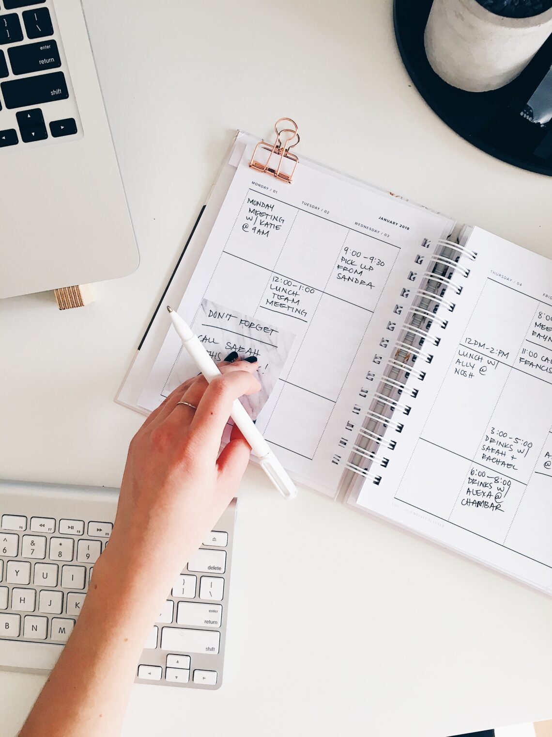 Planning out the week in white planner and white desk